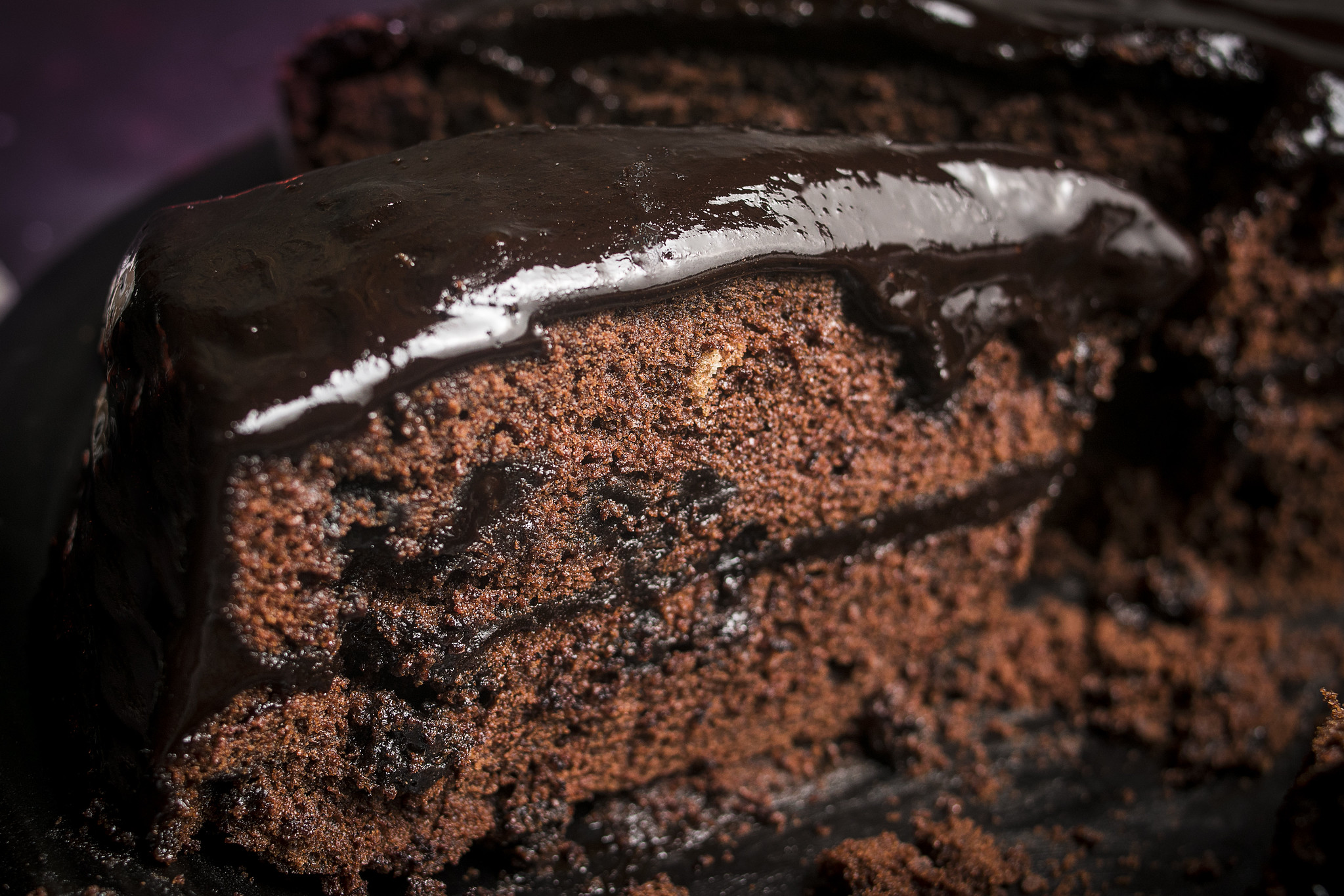 Cut Chocolate Ghoulyard Cake showing dark chocolate sponge, chocolate chips and glossy espresso ganache.
